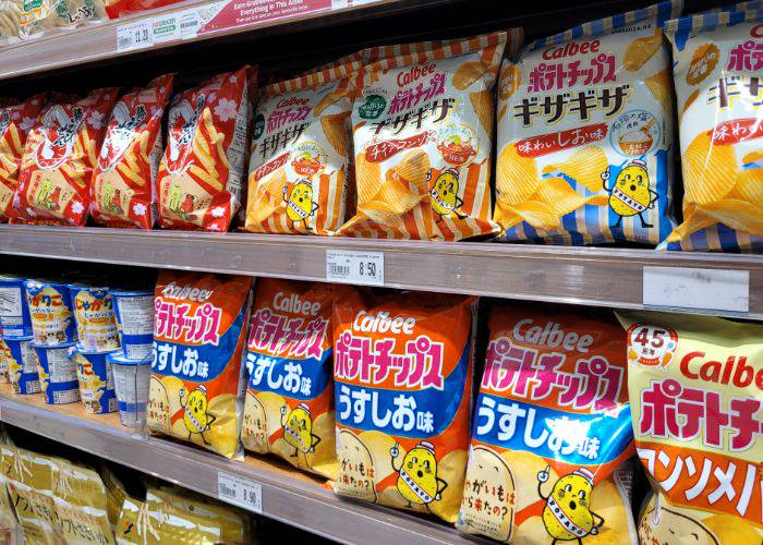 Supermarket shelves filled with different types and flavors of Calbee Chips.